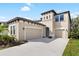 Tan two-story house with a three-car garage and manicured lawn at 14672 Horse Trot Rd, Lithia, FL 33547
