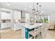 Modern kitchen with white cabinets, large island, and teal accents at 14672 Horse Trot Rd, Lithia, FL 33547