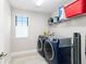 Convenient laundry room with washer, dryer, and shelving at 14672 Horse Trot Rd, Lithia, FL 33547