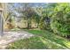 Spacious backyard with lush landscaping and a brick patio at 2122 Oak Forest Ln, Palm Harbor, FL 34683