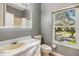 Clean bathroom with a large window, shower/tub combo and updated vanity at 2122 Oak Forest Ln, Palm Harbor, FL 34683