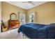 Charming bedroom with antique dresser, comfy bed, and large windows at 2122 Oak Forest Ln, Palm Harbor, FL 34683