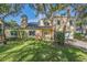 Beautiful two-story house with a solar panel system, lush landscaping, and a spacious yard at 2122 Oak Forest Ln, Palm Harbor, FL 34683
