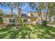 Two-story house with solar panels and a well-manicured lawn at 2122 Oak Forest Ln, Palm Harbor, FL 34683
