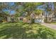 Two-story house with a large yard, driveway and mature trees at 2122 Oak Forest Ln, Palm Harbor, FL 34683
