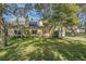 Two-story house with solar panels, lush landscaping and a yard at 2122 Oak Forest Ln, Palm Harbor, FL 34683