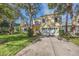 Two-story house with a large yard, driveway and mature trees at 2122 Oak Forest Ln, Palm Harbor, FL 34683