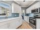 Bright kitchen featuring white cabinets and blue chevron backsplash at 2122 Oak Forest Ln, Palm Harbor, FL 34683