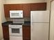 Kitchen with dark wood cabinets and white appliances at 2171 Portofino Pl # 27-2717, Palm Harbor, FL 34683