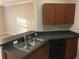 Kitchen with dark wood cabinets and a double sink at 2171 Portofino Pl # 27-2717, Palm Harbor, FL 34683