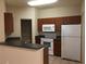 Kitchen with dark wood cabinets and white appliances at 2171 Portofino Pl # 27-2717, Palm Harbor, FL 34683