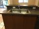 Clean kitchen sink with dark countertop and wood cabinets at 2171 Portofino Pl # 27-2717, Palm Harbor, FL 34683