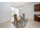 Cozy dining area with a glass table and chairs, situated next to a kitchen at 2941 Adams Cross Dr, Zephyrhills, FL 33540