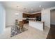 Modern kitchen with dark brown cabinets, an island, and a glass-top dining table at 2941 Adams Cross Dr, Zephyrhills, FL 33540