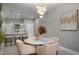 Modern dining area with a round table, chandelier, and adjacent bar area at 29955 Southwell Ln, Wesley Chapel, FL 33543