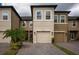 Two-story townhome with a two-car garage, neatly landscaped and situated in a community setting at 29955 Southwell Ln, Wesley Chapel, FL 33543