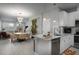 Open concept kitchen with a large island, white cabinets and stainless steel appliances at 29955 Southwell Ln, Wesley Chapel, FL 33543