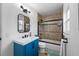 Clean bathroom, featuring a blue vanity, tub shower combo, and a modern mirror at 4220 19Th N St, St Petersburg, FL 33714