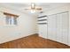 Bedroom with wood-look floors, ceiling fan, and built-in shelving at 6506 Remus Dr, New Port Richey, FL 34653