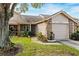 Tan two-story house with brick accents, attached garage, and landscaping at 6506 Remus Dr, New Port Richey, FL 34653