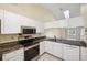 Kitchen with white cabinets, granite counters, and stainless steel appliances at 6506 Remus Dr, New Port Richey, FL 34653