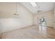 Living room with vaulted ceiling, wood flooring, and access to patio at 6506 Remus Dr, New Port Richey, FL 34653