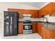 Kitchen with wood cabinets, black appliances and tile floors at 9104 Sandcroft Ct, Tampa, FL 33615