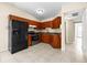 Kitchen with wood cabinets, black appliances and tile floors at 9104 Sandcroft Ct, Tampa, FL 33615