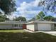 Newly renovated single-story home with gray exterior, orange door and a two-car garage at 1311 4Th W St, Palmetto, FL 34221