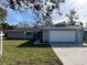 Newly renovated single story home with a gray exterior, red door, and attached garage at 1311 4Th W St, Palmetto, FL 34221