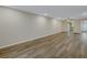 Large living room with wood-look floors and view to kitchen at 3500 Lake Bayshore Dr # K-101, Bradenton, FL 34205