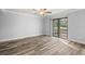 Bright bedroom with wood-look floors and sliding glass door to patio at 3505 Tarpon Woods Blvd # K403, Palm Harbor, FL 34685