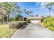 Home with a long driveway, attached garage, and manicured landscaping at 4595 Northwood Ter, Sarasota, FL 34234