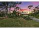 Attractive ranch home exterior at sunset, showcasing landscaping and a large yard at 4595 Northwood Ter, Sarasota, FL 34234