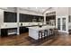 Elegant kitchen with dark cabinetry, marble backsplash, and a large island with seating at 805 Islebay Dr, Apollo Beach, FL 33572