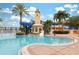 Relaxing pool area with a lighthouse, waterslide, and palm trees at 805 Islebay Dr, Apollo Beach, FL 33572