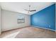 Bedroom with blue accent wall, carpet, and ceiling fan at 8436 Red Roe Dr, New Port Richey, FL 34653