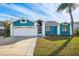 Cute blue house with a white garage door and well-manicured lawn at 8436 Red Roe Dr, New Port Richey, FL 34653