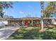 Brick ranch house with a red door, attached garage, and well-manicured lawn at 1340 Williams Dr, Clearwater, FL 33764