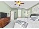 Bright bedroom with king-size bed, dresser, and large TV at 19346 Garden Quilt Cir, Lutz, FL 33558