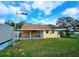 View of the back of the house with a covered patio and large grassy yard at 7211 Waycross Ave, Tampa, FL 33619