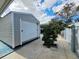 Gray storage shed with a white roll-up door in the backyard at 7211 Waycross Ave, Tampa, FL 33619
