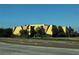 Exterior of a commercial building featuring angular designs, beige stucco siding, and mature landscaping at 9606 Seadale Ct # 101, Riverview, FL 33578