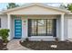 Front view of a renovated home featuring a teal door and black shutters at 1903 E Diana St, Tampa, FL 33610