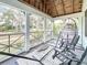 Screened porch overlooks the street with wooden ceiling and hanging chair at 2828 Burlington N Ave, St Petersburg, FL 33713