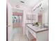 Vanity in pink bathroom with decorative clock, plant, and adjoining bedroom at 3203 Audubon Ct, Tarpon Springs, FL 34688