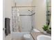 Bathroom featuring a shower-tub combo with decorative curtain and neutral tile at 3203 Audubon Ct, Tarpon Springs, FL 34688