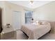 Cozy bedroom with neutral tones, tile floors, and a window with blinds at 3203 Audubon Ct, Tarpon Springs, FL 34688