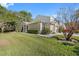 Tan house with green lawn and trees, showcasing a well-maintained exterior at 3203 Audubon Ct, Tarpon Springs, FL 34688