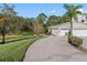 Home exterior featuring a long driveway and two-car garage with adjacent green space at 3203 Audubon Ct, Tarpon Springs, FL 34688